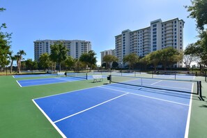 A tennis court with a net, surrounded by trees and buildings. - 5th Floor 3 Bedroom Condo with Semi-Private Elevator (Destin)