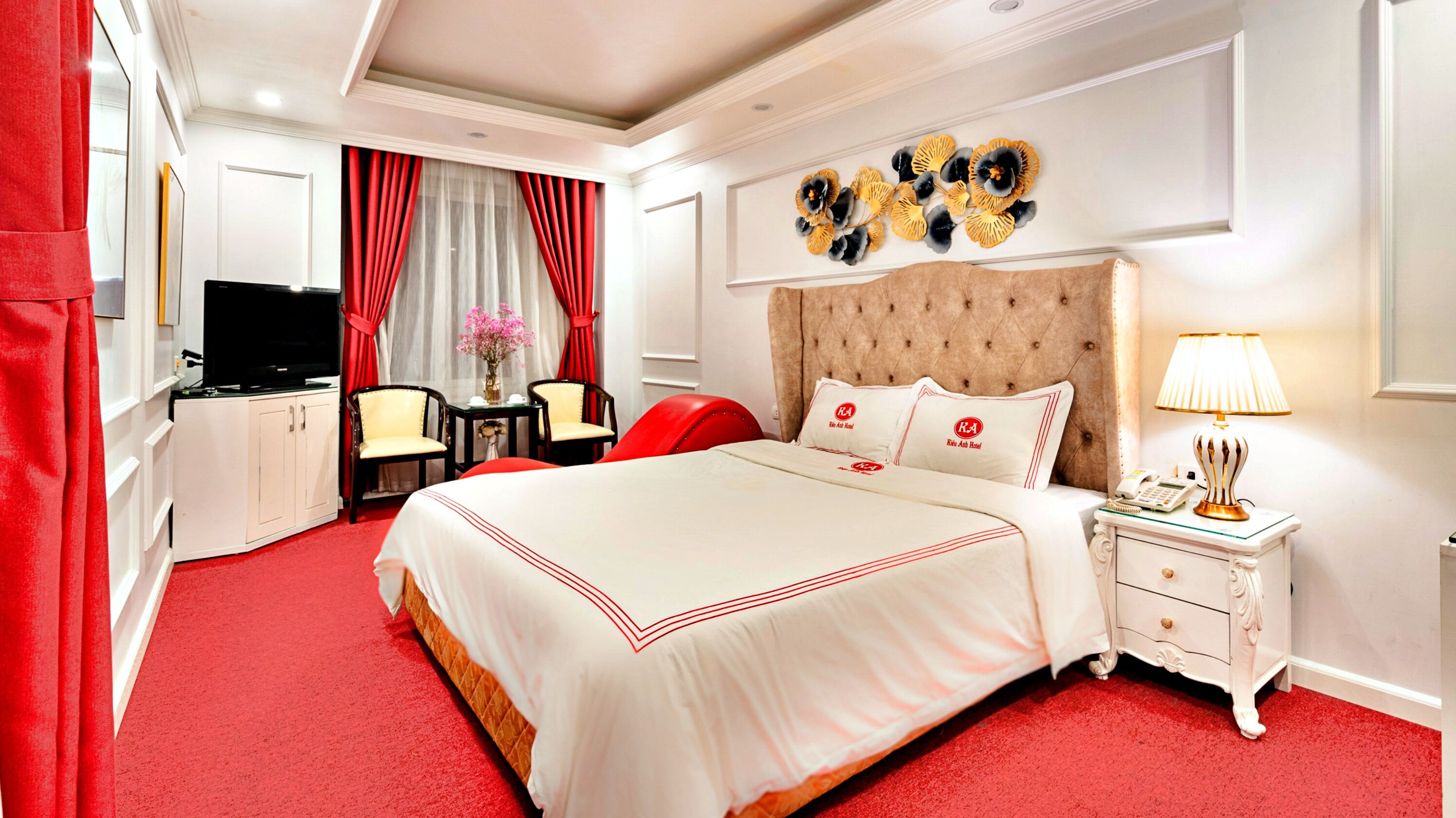 Une chambre d’hôtel avec un grand lit, une télévision, un bureau et une chaise.