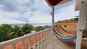 Un balcone con vista sull'oceano, un'amaca e un pavimento piastrellato.
