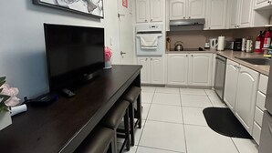 A modern kitchen with white cabinets, a built-in oven, and a black countertop. - Hollywood beach apartment on the beach the biggest in the building all new  (Hollywood)
