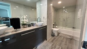 A modern bathroom with a large mirror, a sink, a toilet, and a shower. - Hollywood beach apartment on the beach the biggest in the building all new  (Hollywood)