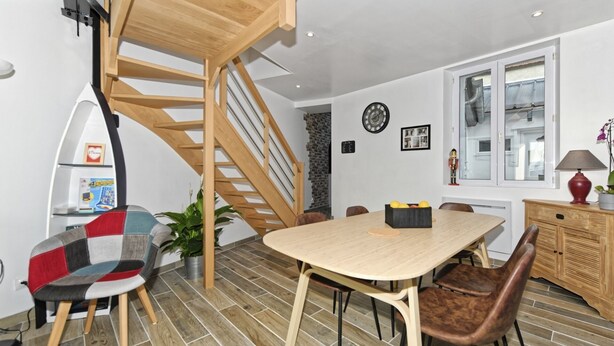A modern kitchen with a wooden staircase, a dining table with chairs, and a kitchen counter. - Gîte bord de mer "A l'abordage" Exceptional view (Fécamp)
