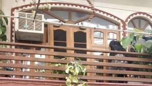 A residential building with a gated entrance, a balcony, and a decorative emblem above the gate. - An independent floor, with one bedroom, kitchen, (Gurugram)