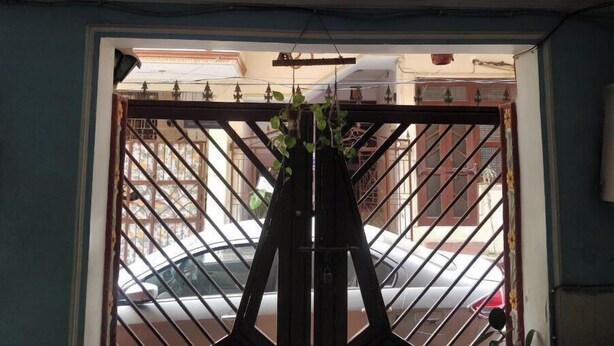 A view through a metal gate with a car parked outside. - An independent floor, with one bedroom, kitchen, (Gurugram)