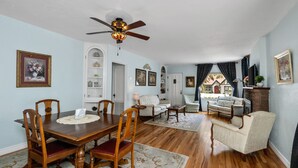 A dining area with a wooden table and chairs, a ceiling fan, and a view of the outside through a window. - Charming Home in Prescotts Historic District. Less than a mile from Whiskey Row. (Prescott)