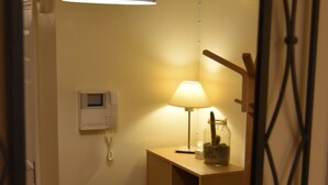 A mirror reflecting a room with a telephone, a lamp, and a cactus in a jar. - Scandinavian City Centre Apartment (Worcester)