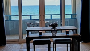Un balcon avec une table et des chaises, un vase et une bougie.