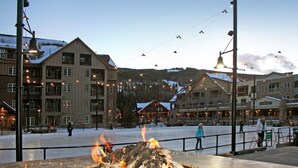 Ein Hotel mit mehreren Etagen, Außenbereichen zum Verweilen und einer Feuerstelle.