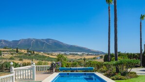 Una piscina con vistas a un pueblo y montañas al fondo.