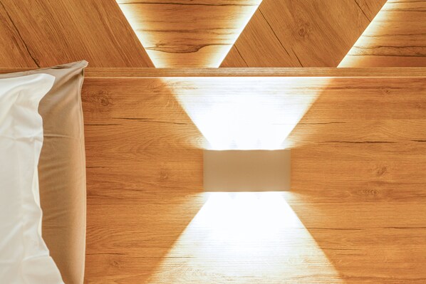 A wooden ceiling with a geometric pattern and a central light fixture.