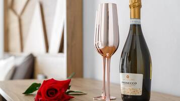 Une bouteille de Prosecco Extra Dry et une rose sur une table en bois.