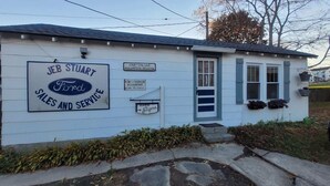 A building with a sign for JEB STUART Ford Sales and Service, a volunteer program, and a sign for R.M. Hodgin Accountant Income Tax Service.