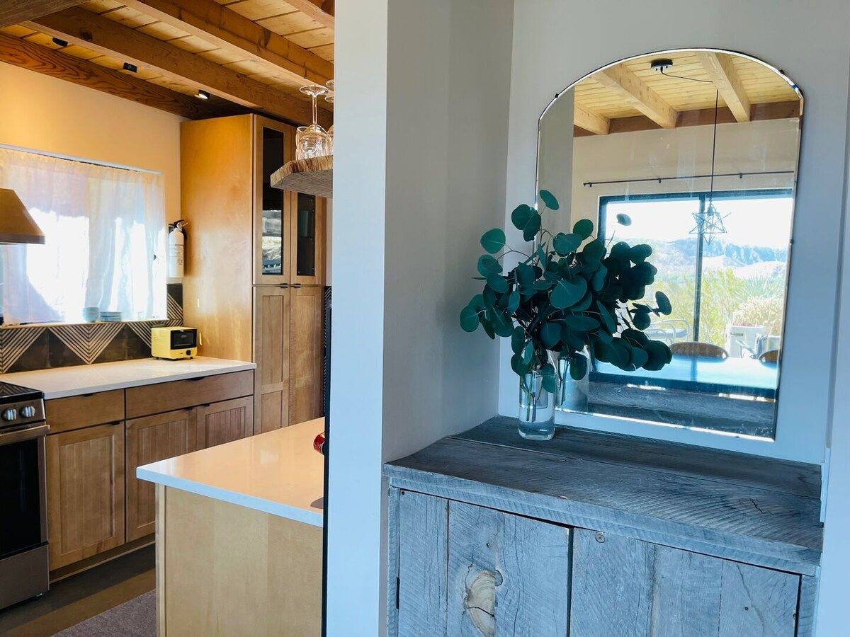 A kitchen with wooden cabinets, a built-in oven, and a window with a view of the outdoors.