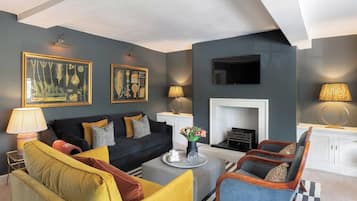 A modern living room with a sofa, armchairs, a coffee table, and artwork on the walls.