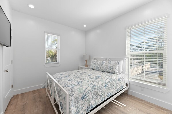 Une chambre à coucher avec un lit, une fenêtre et une table de chevet.