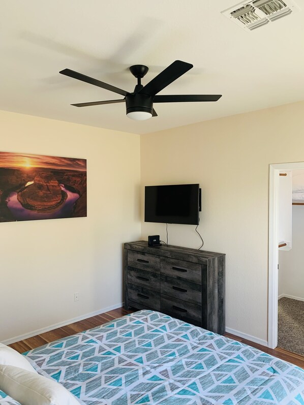 A bedroom with a bed, a ceiling fan, a mounted TV, and a dresser. - Home sweet home (Glendale)