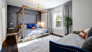 Ein modernes Schlafzimmer mit einem Himmelbett, einem Nachttisch, einer Lampe und einem großen Fenster mit Vorhängen.