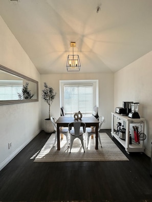 Enjoy meals in this dining area with a dining table, comfortable chairs, and a large mirror.