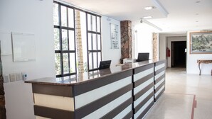 Una recepción con diseño moderno, un ventanal grande y un panel informativo en la pared.
