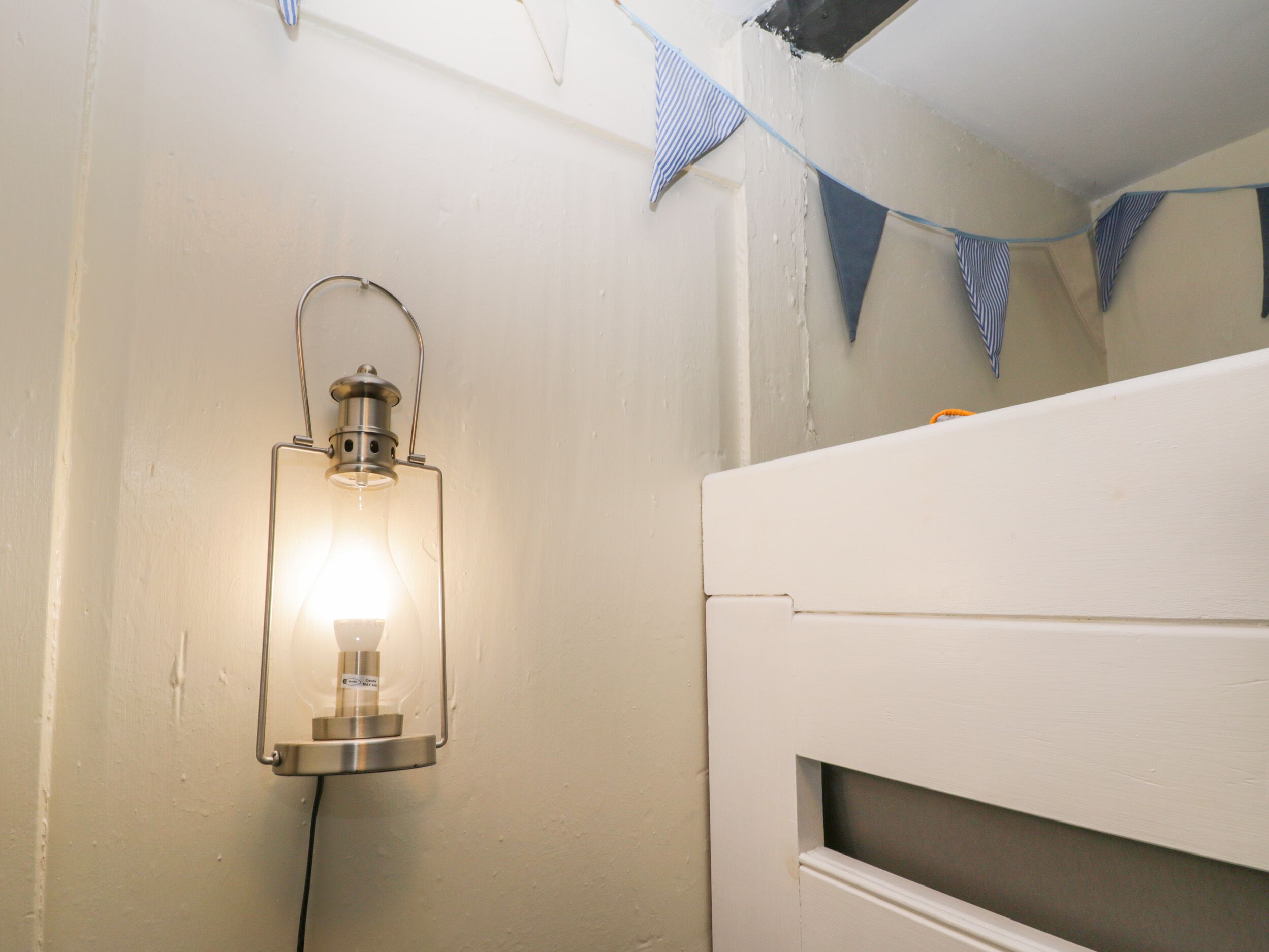 A bathroom with a wall-mounted light fixture and a towel rack.