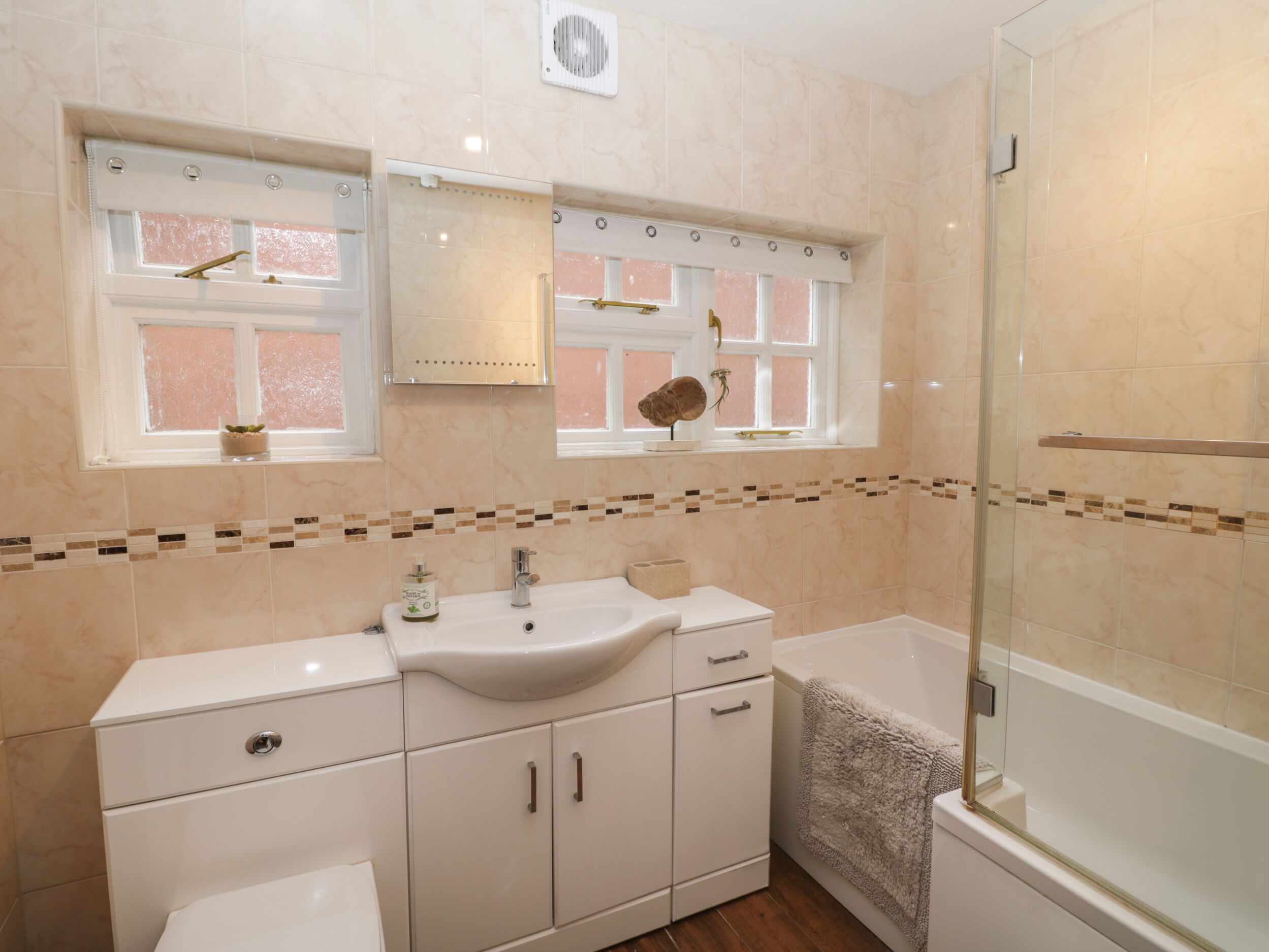 Ein modernes Badezimmer mit Waschbecken, Spiegel und Dusche.