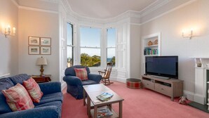 A living room with a sofa, armchair, coffee table, TV, and fireplace. - Seascape - 3 Bedrooms (North Berwick)