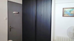 A bedroom with a bed, a wardrobe, a radiator, and a painting on the wall. - Directly on the beach for this charming one-bedroom flat with private parking - 4OND28 (SAINT CYPRIEN PLAGE)