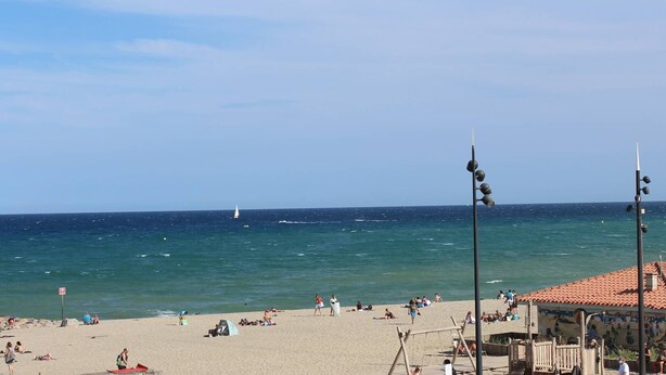 A beach with a sandy shore, a few people, and a sailboat in the distance. - Directly on the beach for this charming one-bedroom flat with private parking - 4OND28 (SAINT CYPRIEN PLAGE)
