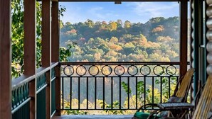 A wooden deck with a metal railing, overlooking a forested hillside. - Rustic/Modern Lodge near French Lick - Groups and Families (West Baden Springs)
