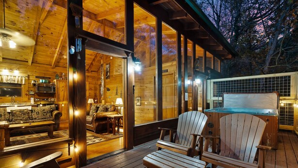 A cozy wooden cabin with a dining area, a hot tub, and a large window overlooking the forest. - Free Dollywood Tix/Pool/Arcade/Spacious/HotTub/ (Sevierville)