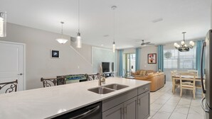 A modern kitchen with a central island, stainless steel appliances, and pendant lighting.