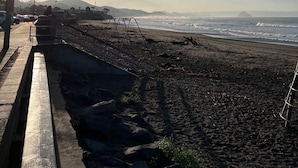 A beach with a paved walkway, street lamps, and a view of the ocean and distant mountains. - WFH surfer dream spot in Morro Bay - Looking for a March & April booking (Morro Bay)