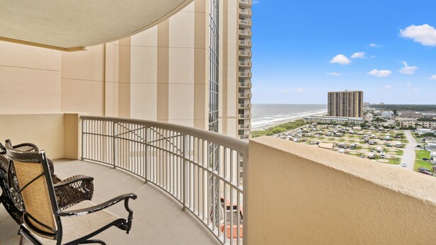 Ein Balkon mit Blick auf Strand und Parkplatz.