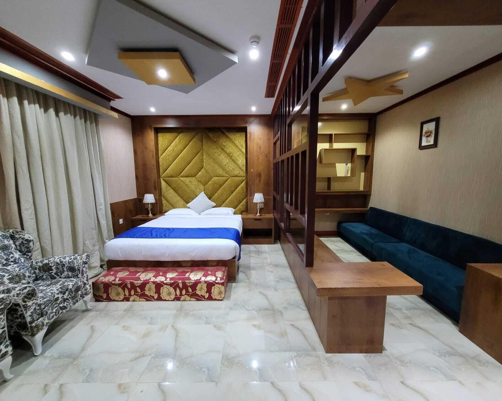 A hotel room with a bed, a sofa, a small table, and a chair.