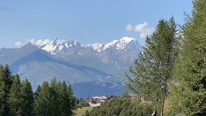 A mountain landscape with snow-capped peaks and a small settlement in the valley. - Coquet studio, heart of the resort, sleeps 4, south-west facing (Bourg-Saint-Maurice)
