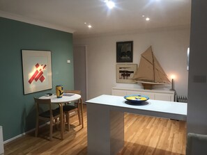 Cozy retreat with a round dining table, console table, and sailboat model.