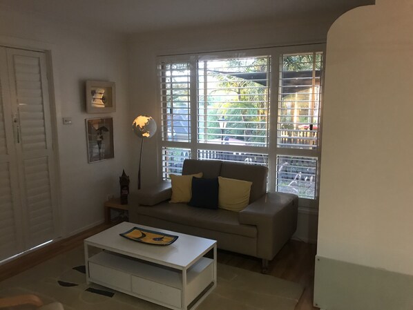 Relax in this inviting living room with a sofa, coffee table, and globe lamp.