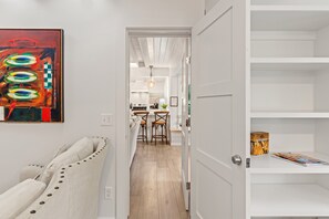 A hallway with a white door leading to a kitchen area.