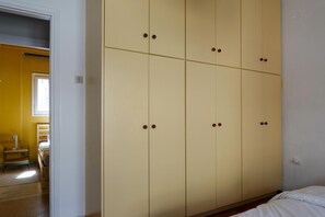 Une pièce comprenant une grande armoire, un lit et une chaise.