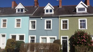 A row of terraced houses with distinct colors and a car parked in front. - Lovely 4-bed Victorian House in Bangor by the sea (Bangor)