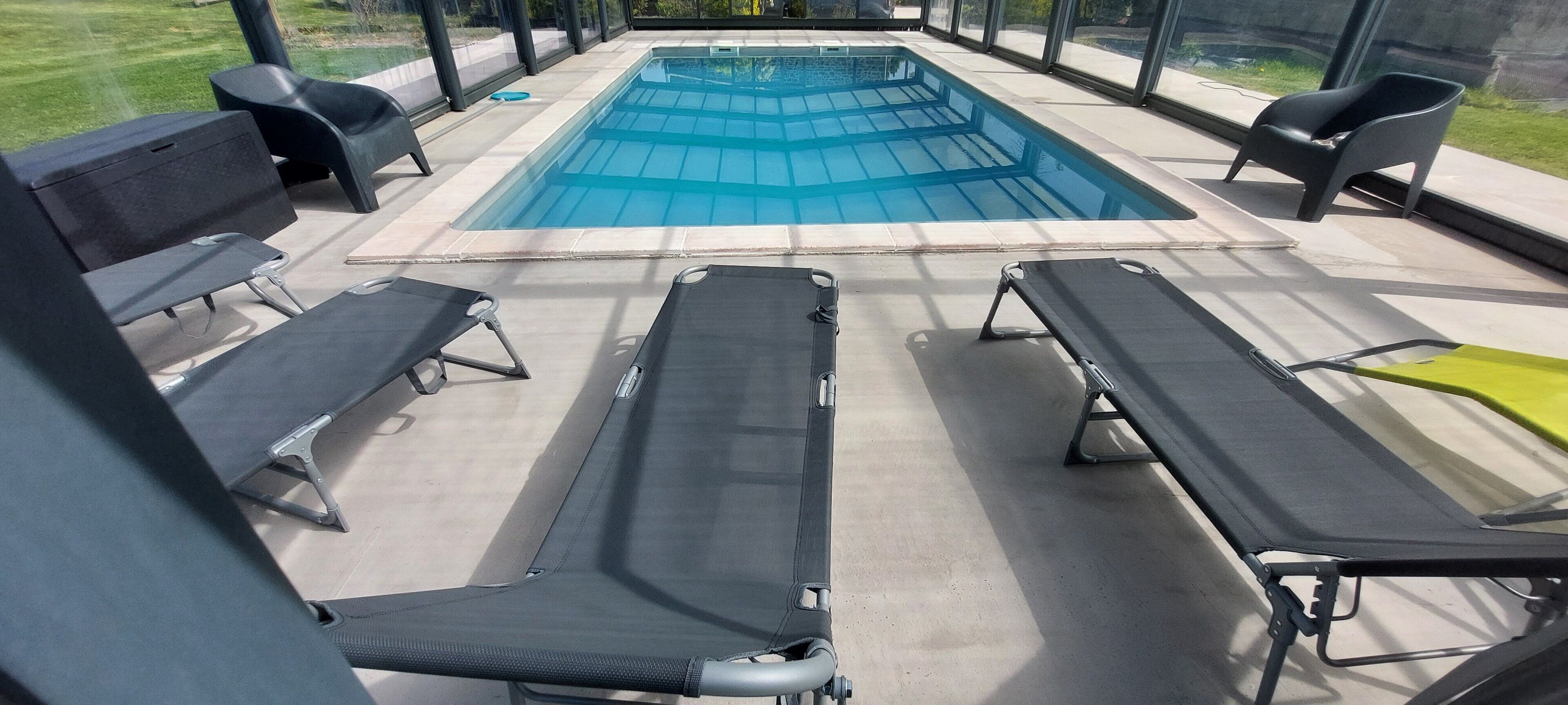 Zona de piscina con sillones de descanso y vista a la piscina.