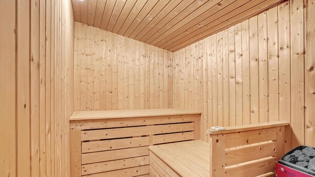 Sauna, jonka seinät ja penkit ovat tehty puusta.