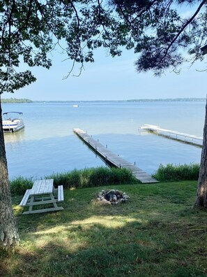 Enjoy serene lakeside views from the comfort of your own space, with a dock, picnic table, and fire pit area nearby.