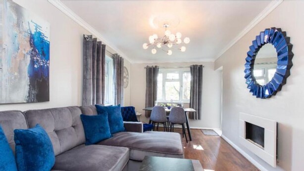 A modern living room with a sectional sofa, a dining area, and a fireplace. - Beautiful 1-bed Apartment in York Near Gym (York)