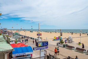 A beachside promenade with a boardwalk, beach, and ocean view.