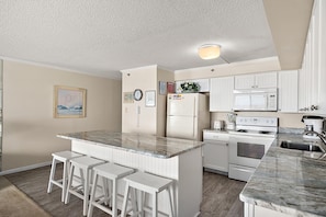 A kitchen with white cabinets, a marble countertop, a refrigerator, a microwave, an oven, and a sink. - 2 br 2 bath, ocean and boardwalk front at 3rd St / large balcony (Ocean City)