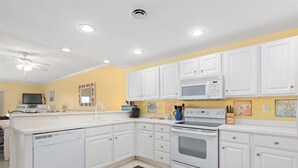 A kitchen with white cabinets, a microwave, an oven, and a dishwasher. - 3 br oceanview 45th St with pool (Ocean City)