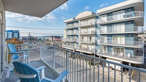 A multi-story hotel with balconies, a parking area, and a view of the beach. - 3 br oceanview 45th St with pool (Ocean City)