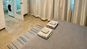 Ein Hotelzimmer mit Bett, Waschmaschine und Bad.