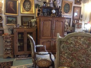 Ein Zimmer mit einem Holzkasten, einem Sessel und einem Sofa mit Blumenmuster.